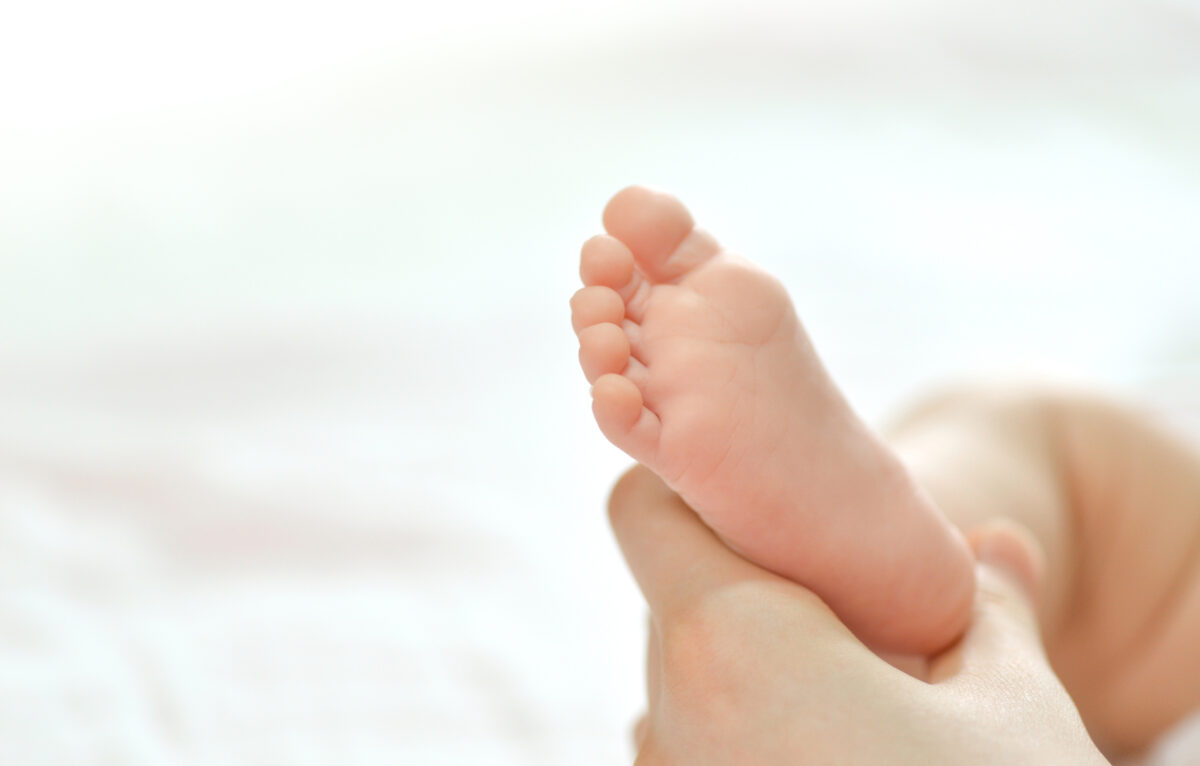 Baby feet in mother hands. Mom and her Child. Happy Family concept. Beautiful conceptual image of Maternity ©