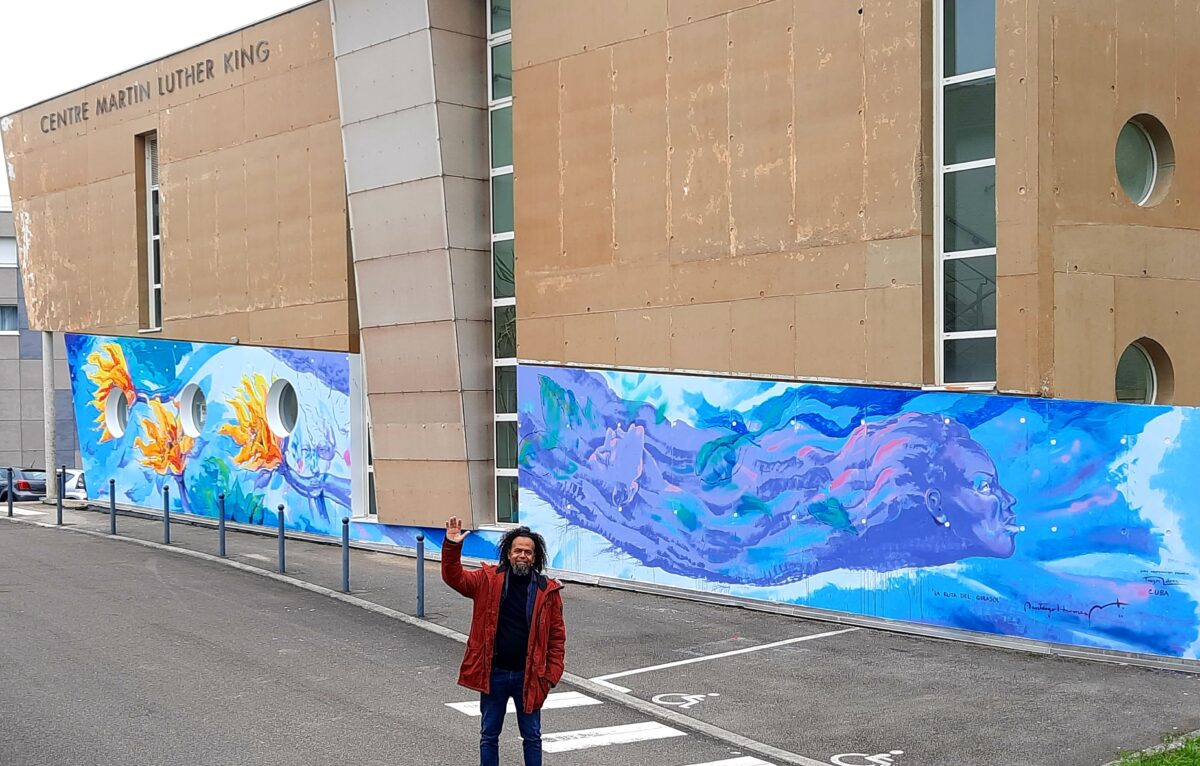 L’artiste Santiago Hermès devant son œuvre murale. © DR